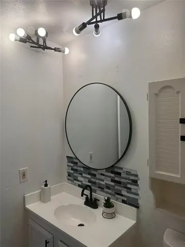 a bathroom with a sink a mirror and a toilet