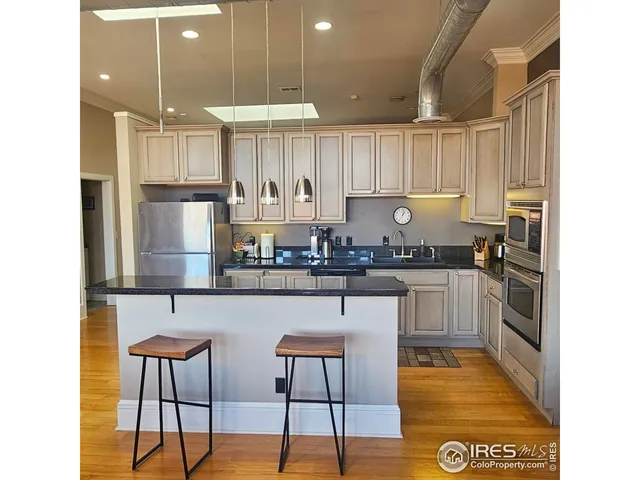 a kitchen with granite countertop a sink stainless steel appliances and cabinets