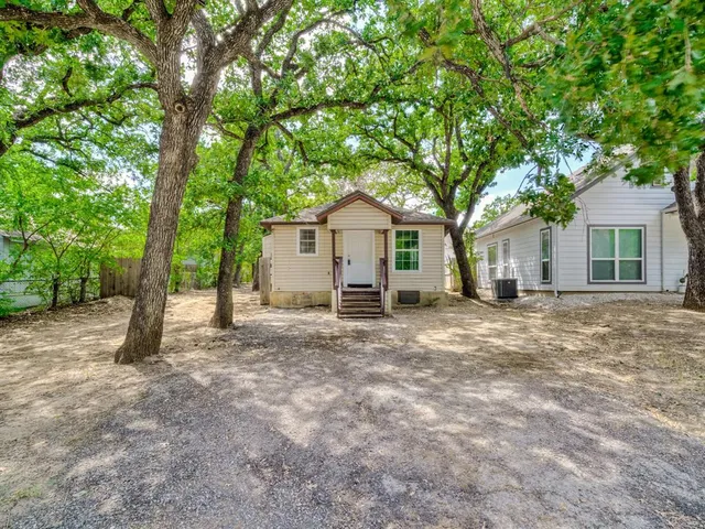 a view of a house with a tree in front of it