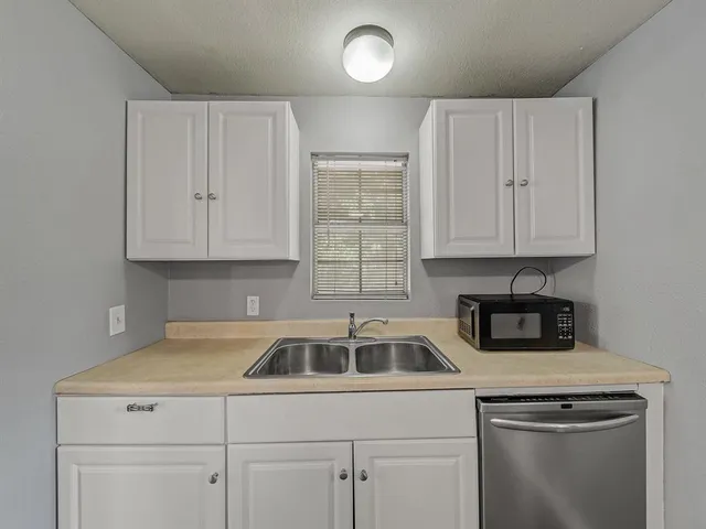 a kitchen with white cabinets and a sink