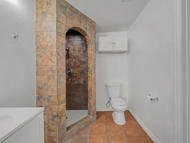 a bathroom with a toilet and a shower