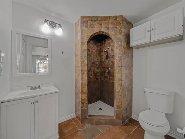 a bathroom with a shower a toilet and a sink
