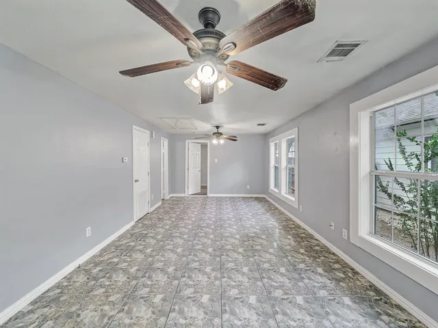 an empty room with fan and windows