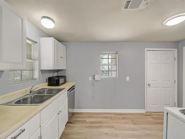 a kitchen that has a sink cabinets counter space and a window