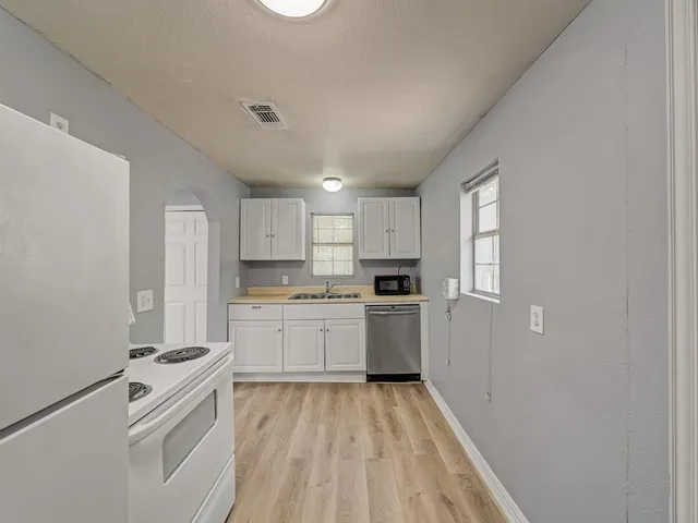a kitchen with a white stove top oven and sink