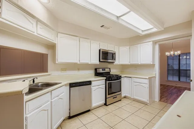 a kitchen with cabinets appliances a sink and a counter top space