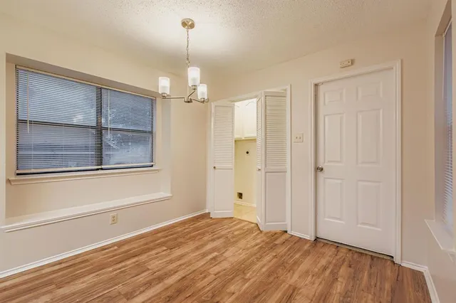 a view of empty room with window and chandelier fan