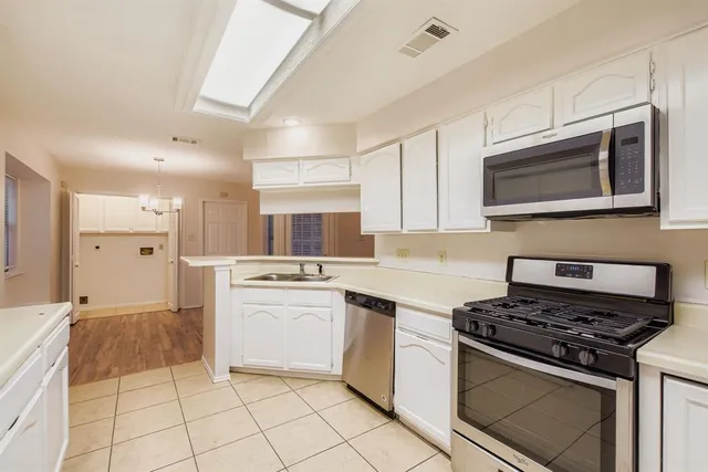 a kitchen with stainless steel appliances a stove microwave and cabinets