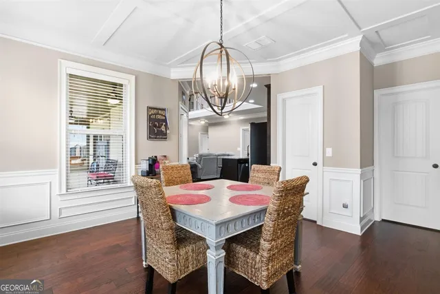 a dining room with furniture a chandelier and wooden floor
