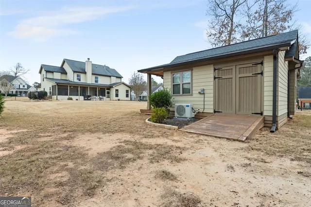 a front view of a house with a garden and lake view