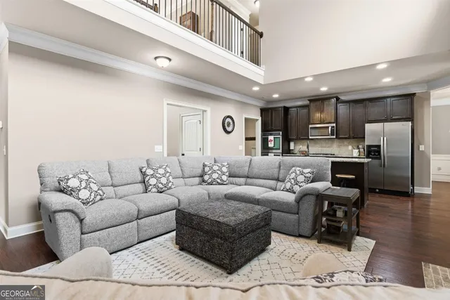 a kitchen with stainless steel appliances granite countertop a kitchen island a stove a refrigerator and a sink with wooden floor