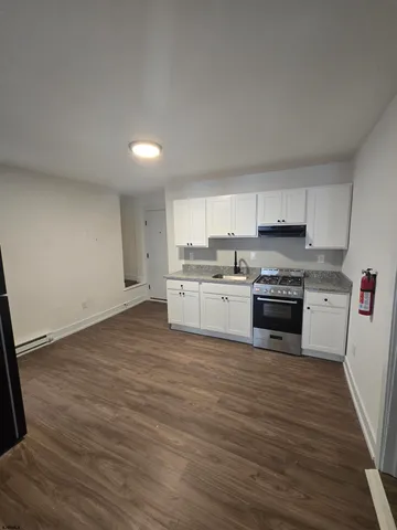 a kitchen with wooden floors and white stainless steel appliances