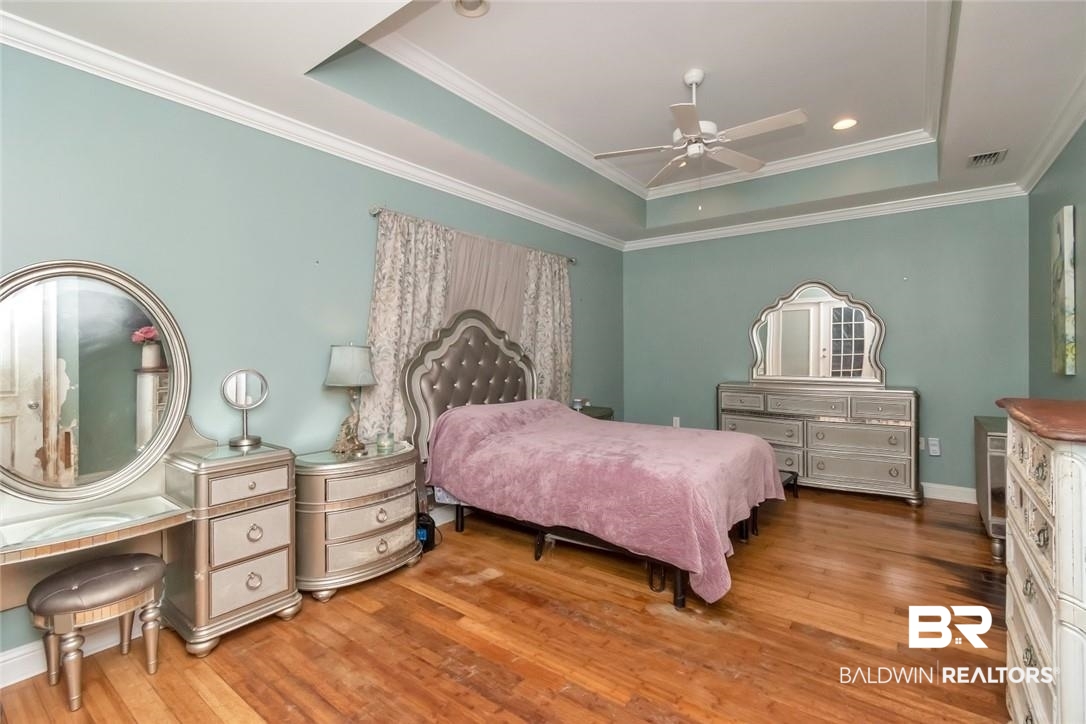 7170 Pierson Drive Mobile, AL 36619 - Photo 12 of 29 Bedroom featuring a raised ceiling, ceiling fan, hardwood / wood-style flooring, and crown molding