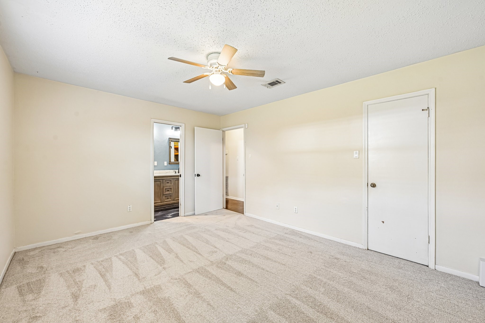8 Arlington Street Conroe, TX 77301 - Photo 25 of 37 Another view of Primary Bedroom (downstairs). Door on right is walk-in closet. Door in middle leads to hallway. Door to the left leads to recently remodeled primary bathroom.