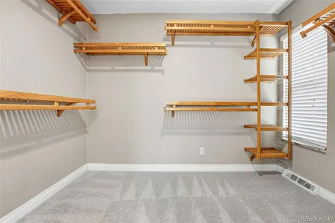 an empty room with closet and a chandelier fan