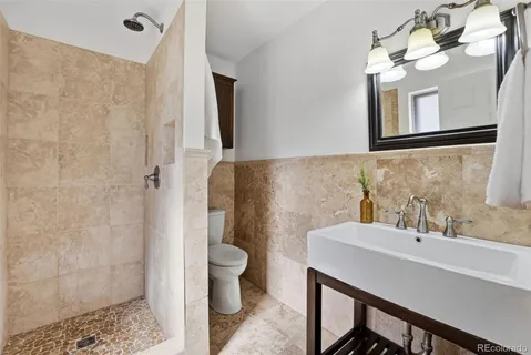 a bathroom with a sink a toilet and a mirror