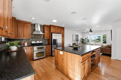 a kitchen with stainless steel appliances granite countertop a sink stove and refrigerator
