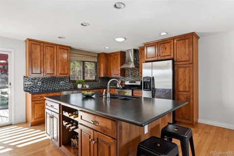 a kitchen with stainless steel appliances granite countertop a sink a stove and a refrigerator