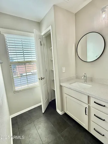a bathroom with a granite countertop sink toilet a mirror and a tub