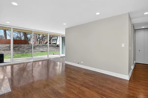 a view of an empty room with wooden floor and a fireplace