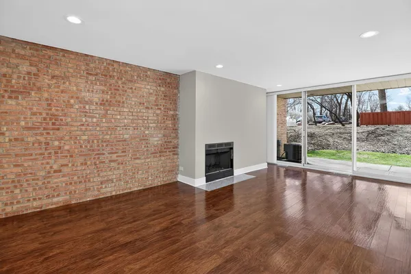 a view of empty room with wooden floor and fireplace