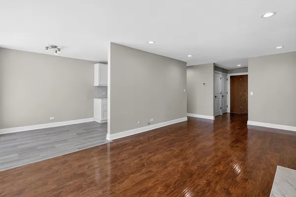 a view of an empty room with wooden floor