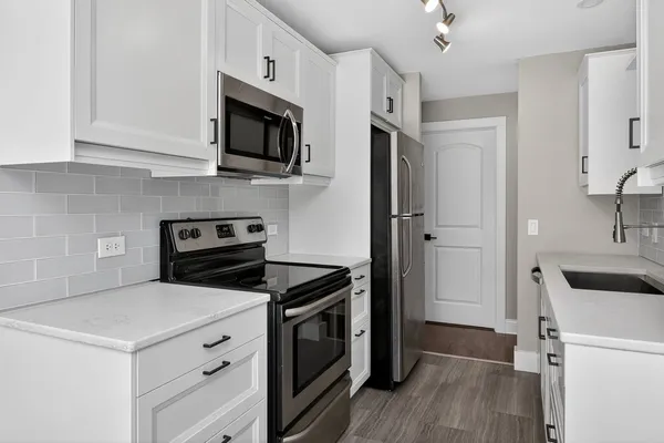 a kitchen with stainless steel appliances a stove microwave and a refrigerator