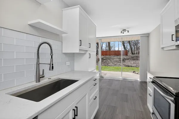 a view of a kitchen counter space a stove and wooden floor
