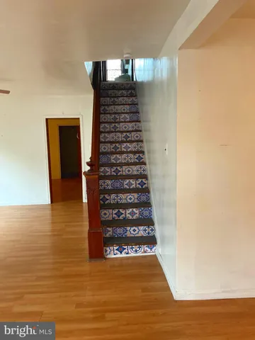 an empty room with wooden floor cabinet and windows