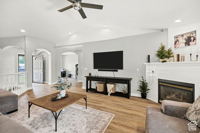 2280 South 450 West Perry, UT 84302 - Photo 22 of 38 Living area featuring light wood finished floors, recessed lighting, arched walkways, a glass covered fireplace, and lofted ceiling