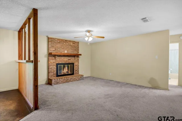 a view of an empty room with a fireplace and a window