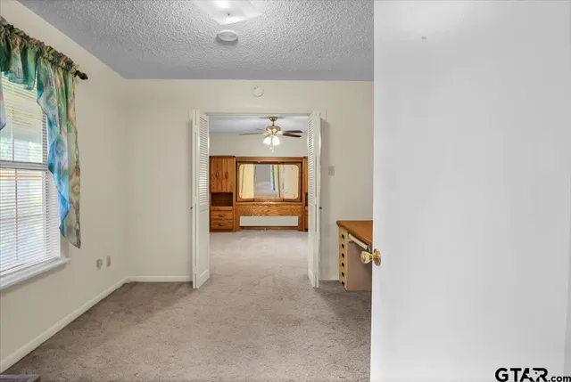 a view of a hallway to rooms and kitchen