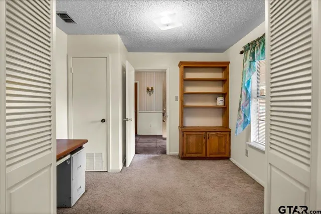 a view of an empty room and a bathroom