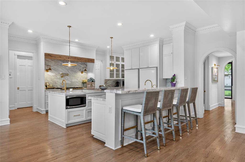6331 Waggoner Drive Dallas, TX 75230 - Photo 5 of 36 a kitchen with stainless steel appliances kitchen island granite countertop a table chairs and a sink