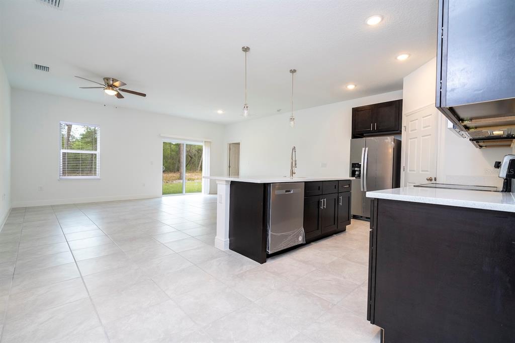 1533 West Diamond Road Citrus Springs, FL 34434 - Photo 5 of 66 a large room with stainless steel appliances kitchen island granite countertop a refrigerator a sink and a stove