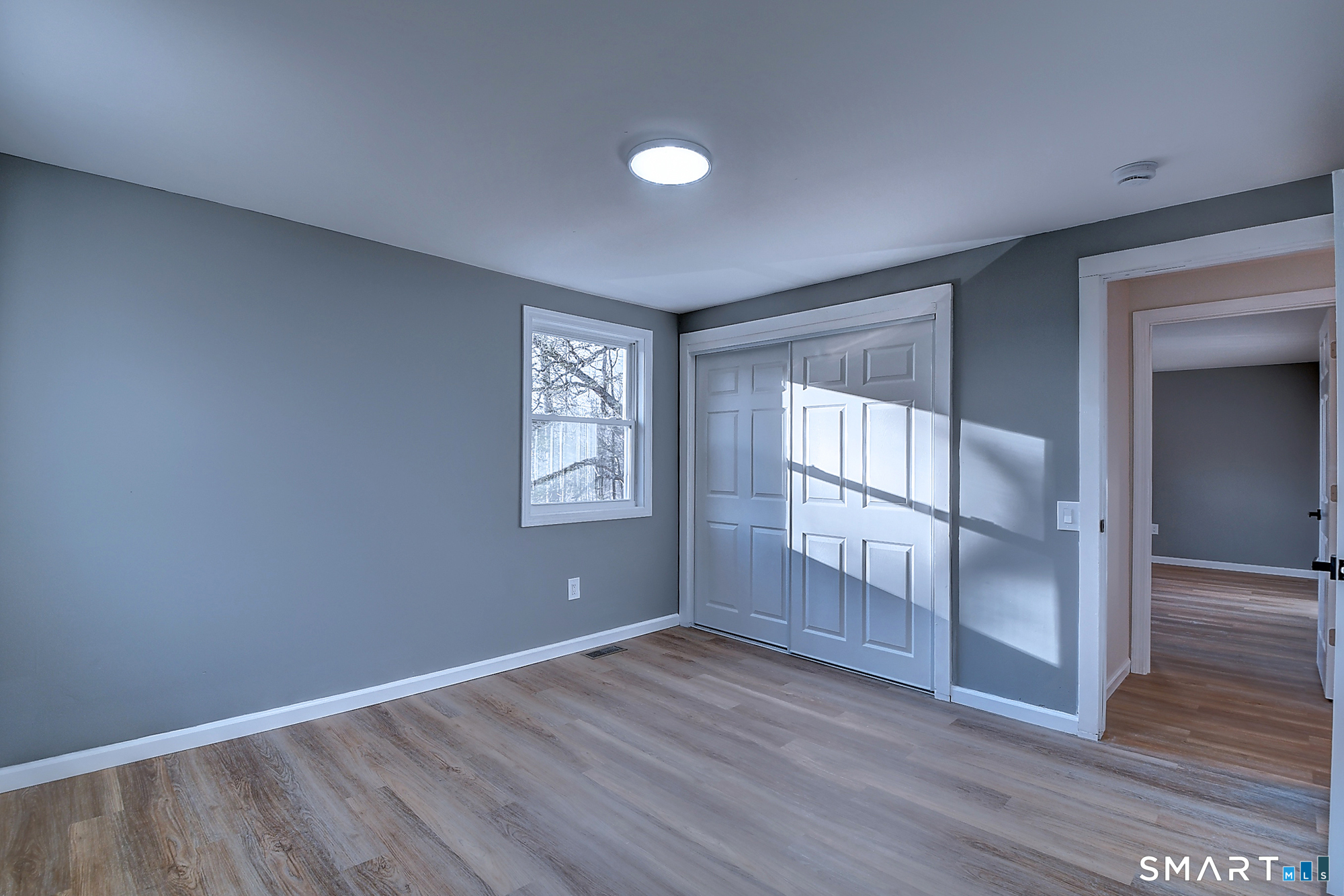 24 Dunay Road Stafford Springs, CT 06076 - Photo 15 of 38 an empty room with wooden floor and windows with curtains