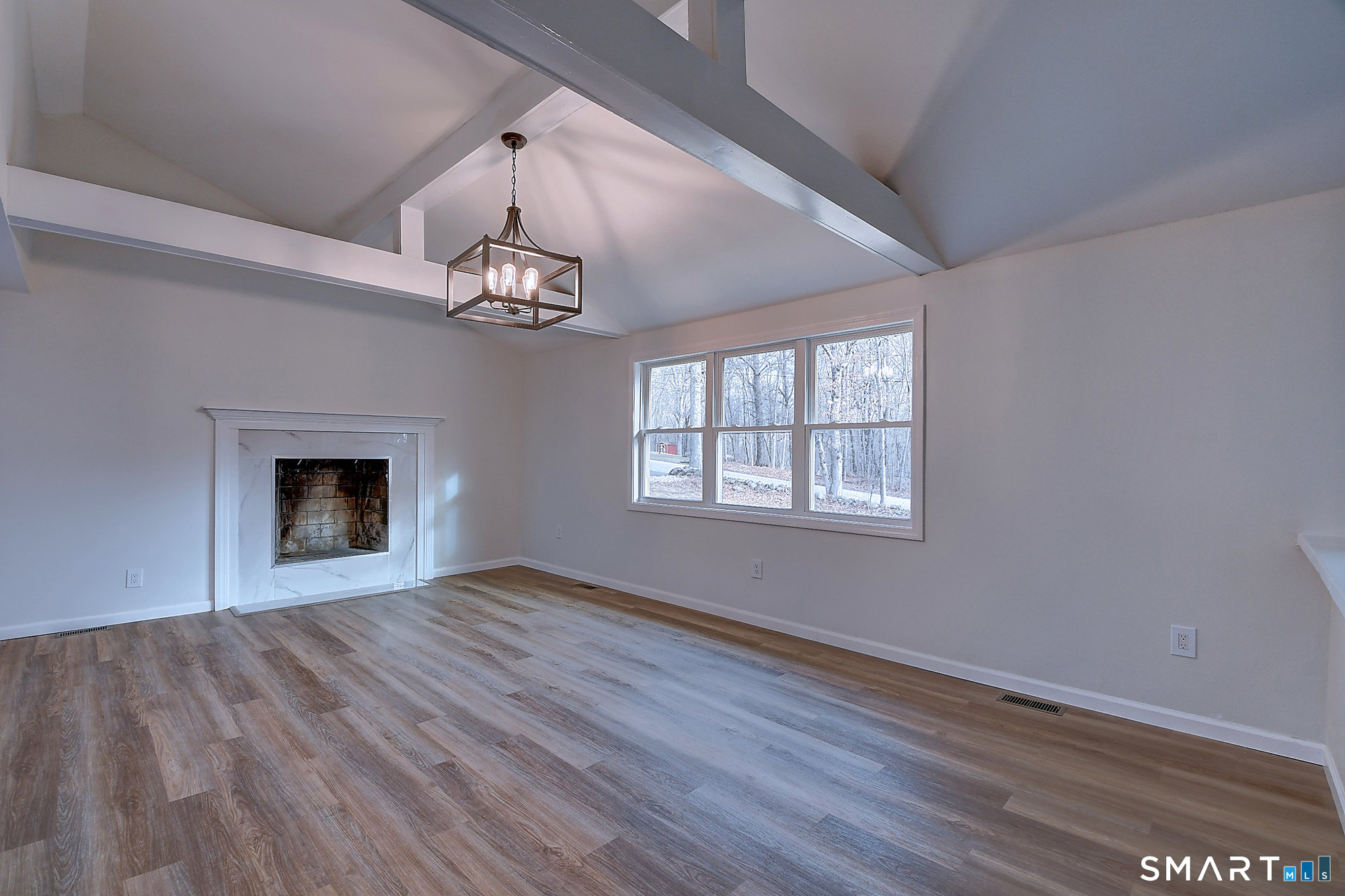 24 Dunay Road Stafford Springs, CT 06076 - Photo 10 of 38 a view of an empty room with wooden floor fireplace and a window