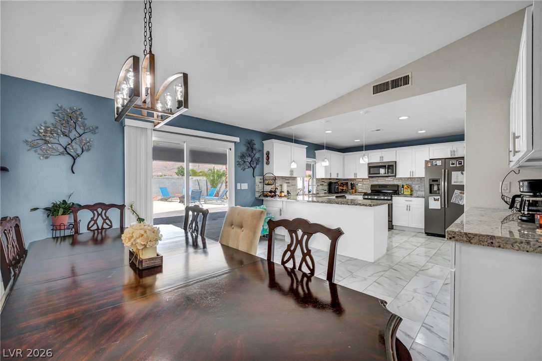 5882 Rio Tinto Way Las Vegas, NV 89110 - Photo 24 of 56 An open-concept design seamlessly connects the dining area to a well-appointed kitchen, ideal for entertaining.
