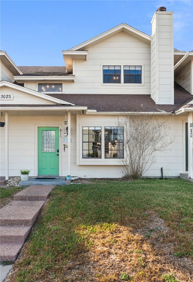 a view of a white house with a big yard and large trees