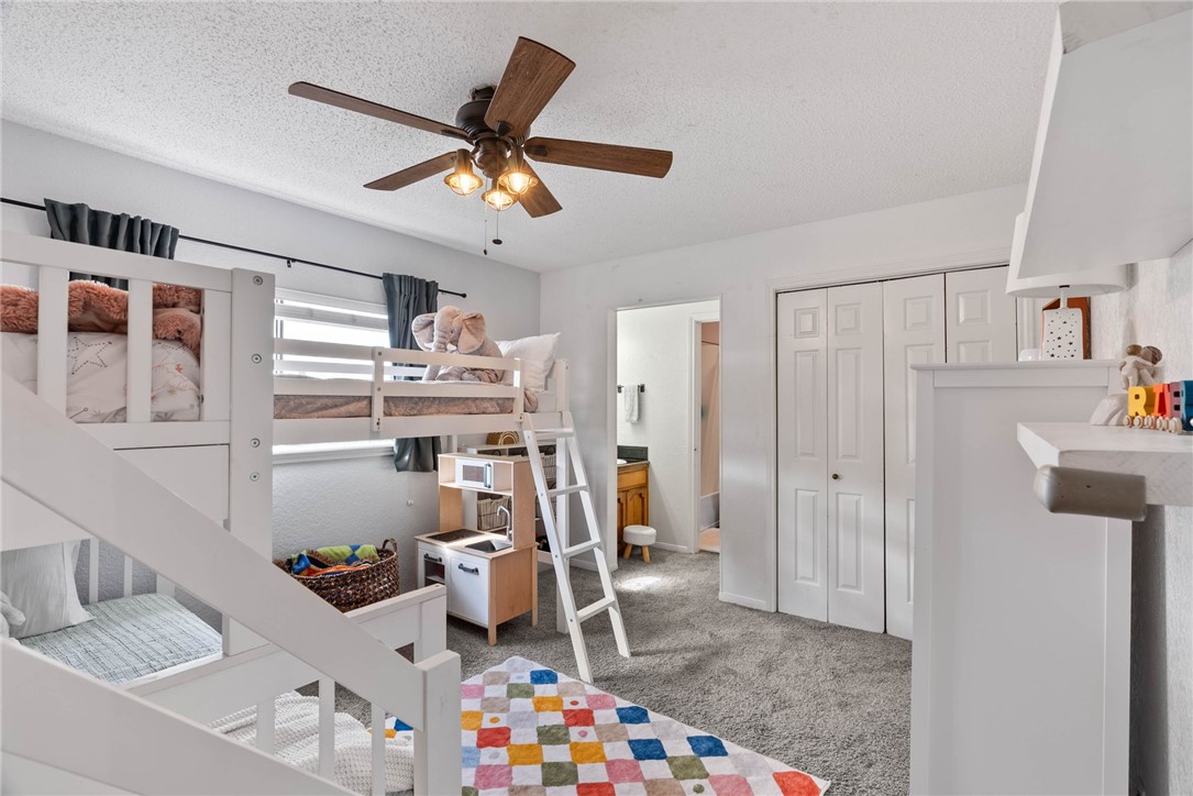 3025 Quail Springs Road, Unit B11 Corpus Christi, TX 78414 - Photo 16 of 20 a room with furniture a clock and a ceiling fan
