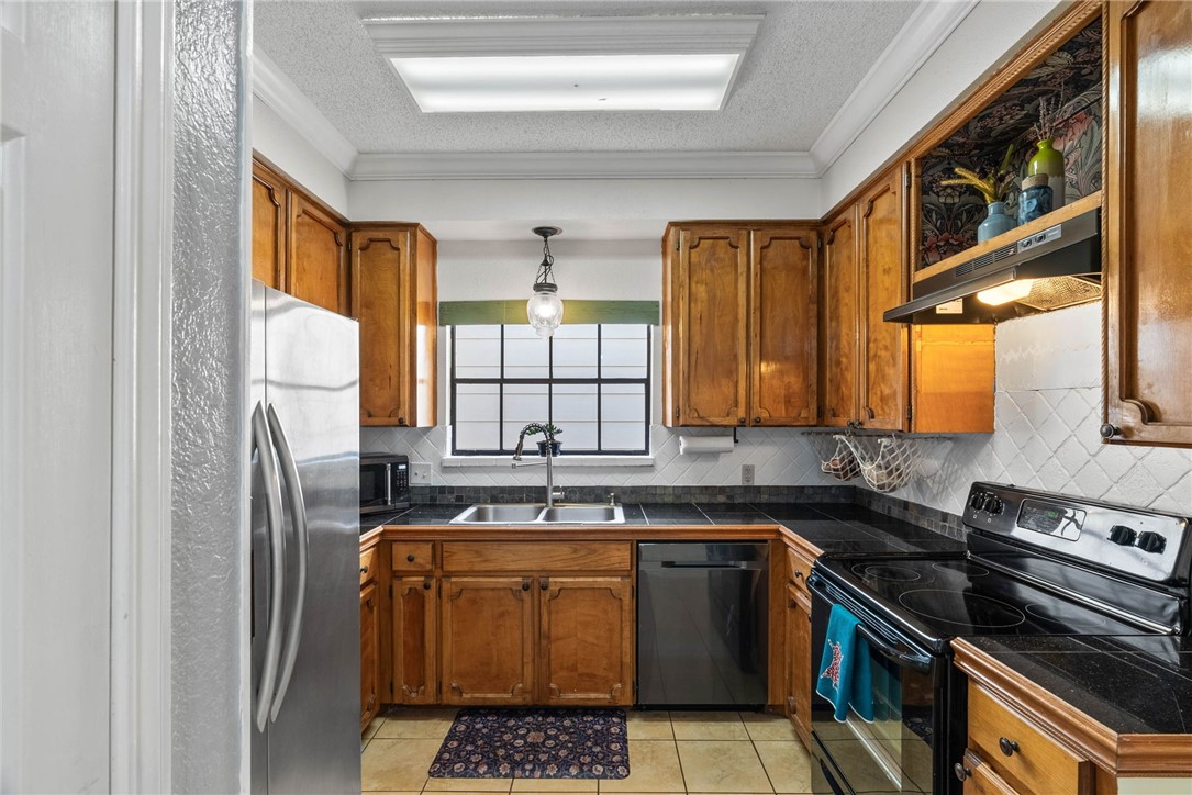 3025 Quail Springs Road, Unit B11 Corpus Christi, TX 78414 - Photo 6 of 20 a kitchen with stainless steel appliances granite countertop a stove a sink and a microwave