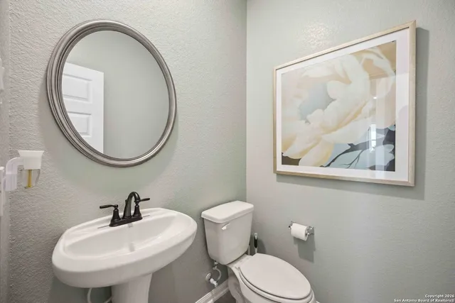 a bathroom with a toilet a sink and a mirror