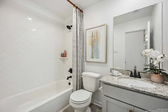 a bathroom with a granite countertop sink a toilet and shower