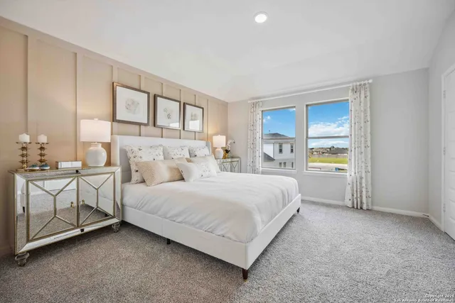 a spacious bedroom with a bed and a cabinets