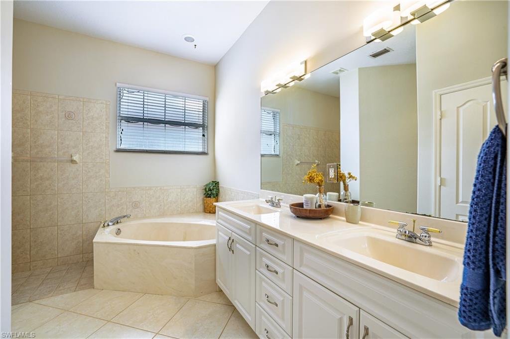 5235 Malvern Court Naples, FL 34112 - Photo 15 of 28 a bathroom with a granite countertop sink mirror and bathtub