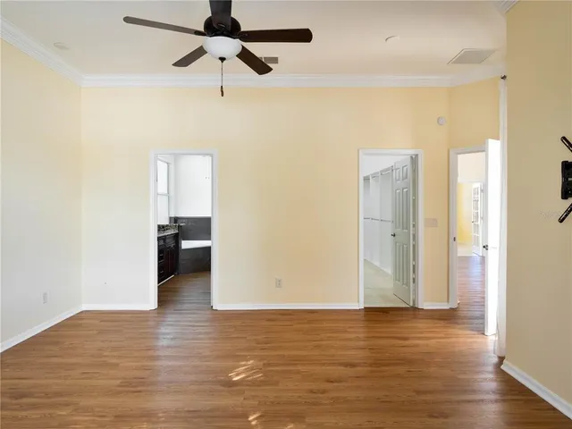 a view of a room with wooden floor and ceiling fan