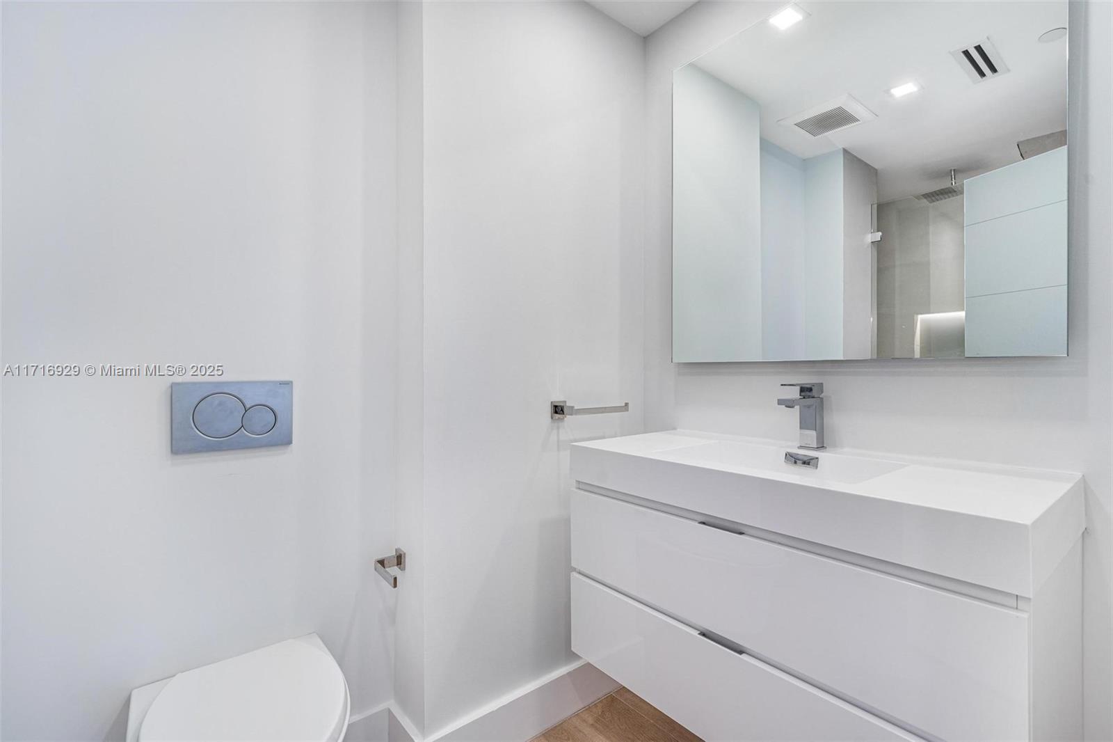 151 Crandon Boulevard, Unit 534 Key Biscayne, FL 33149 - Photo 24 of 49 a bathroom with a toilet sink vanity and mirror