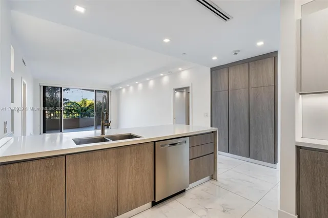a kitchen with kitchen island granite countertop a sink and a large window
