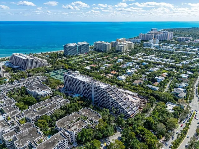 an aerial view of a city with lots of residential buildings ocean and mountain view in back