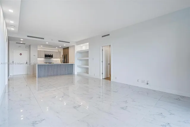 an empty room with kitchen and window